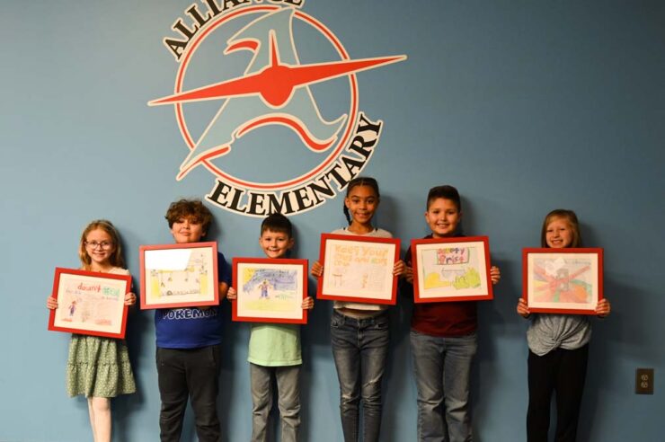 Alliance Elementary School contest winners holding artwork
