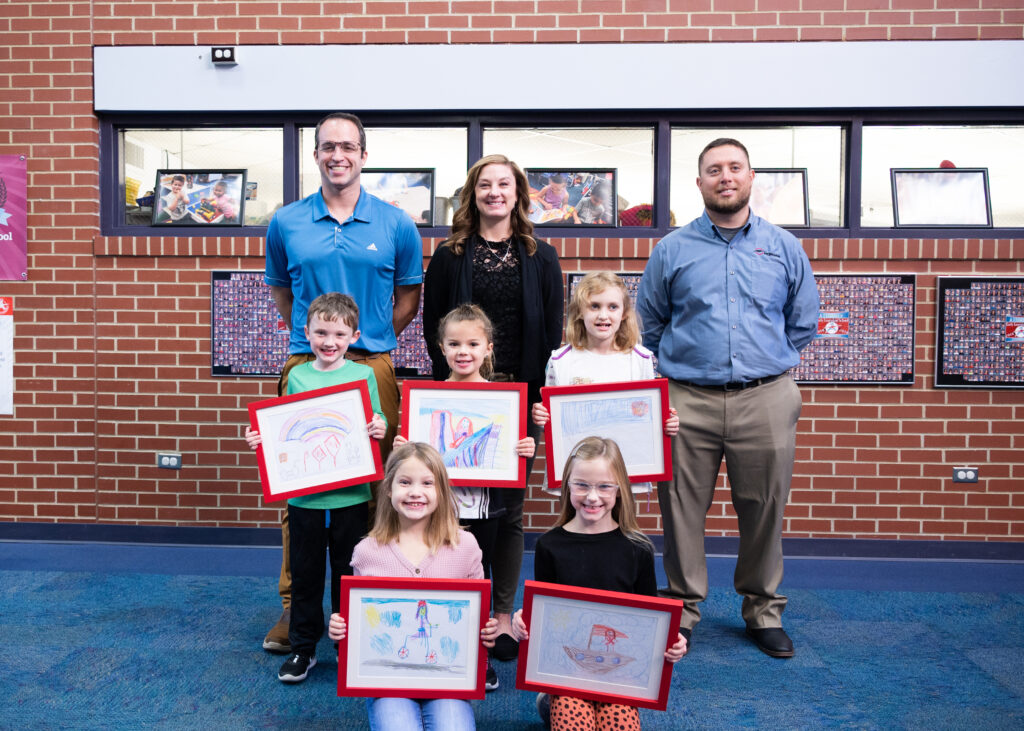 Students and school officials pictured with winning artwork.