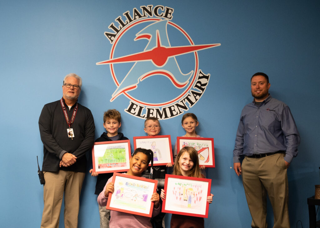 Students and school officials pictured with winning artwork.