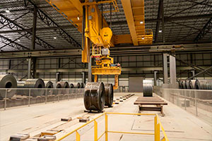 Heppenstall tongs moving a coil of steel