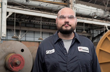 Morgan employee standing in front of a machine