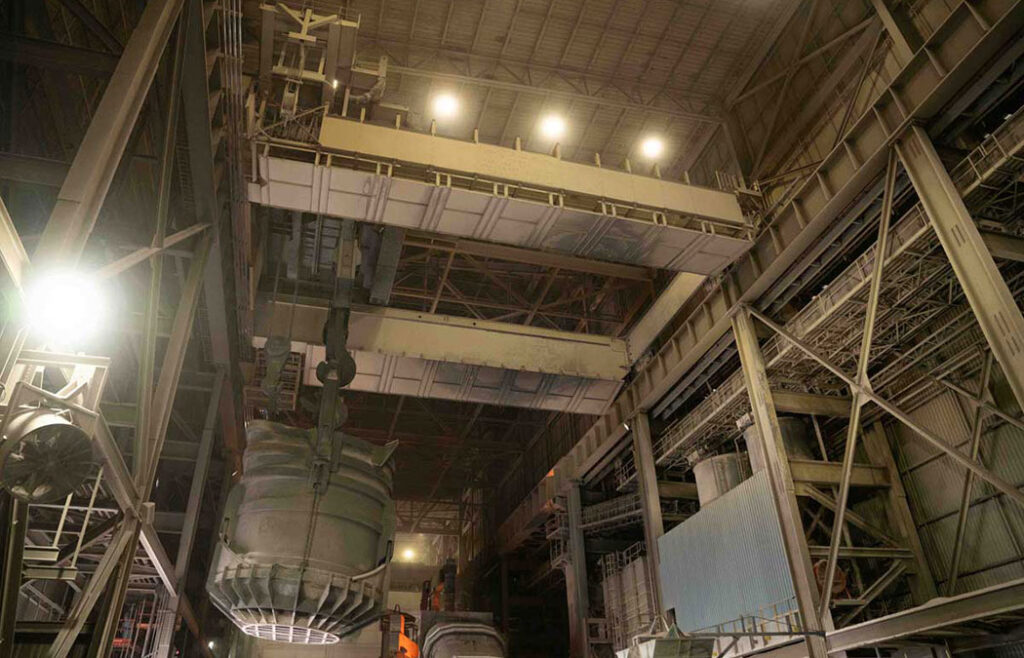 Trolley supporting a ladle bucket in the melt shop of a steel mill.