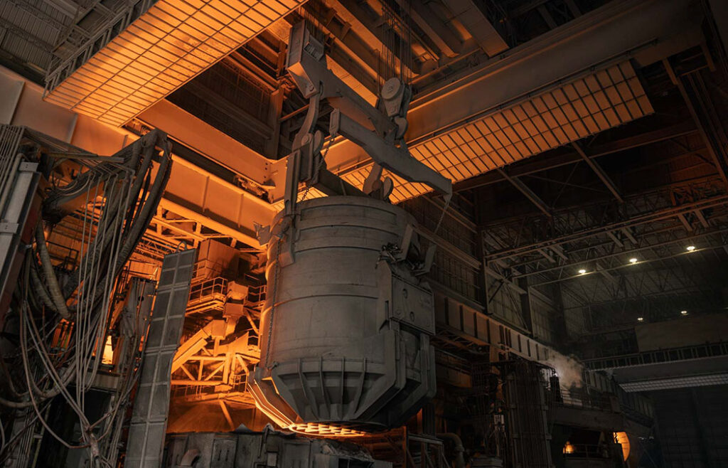 Charge crane prepares to load furnace with scrap metal.