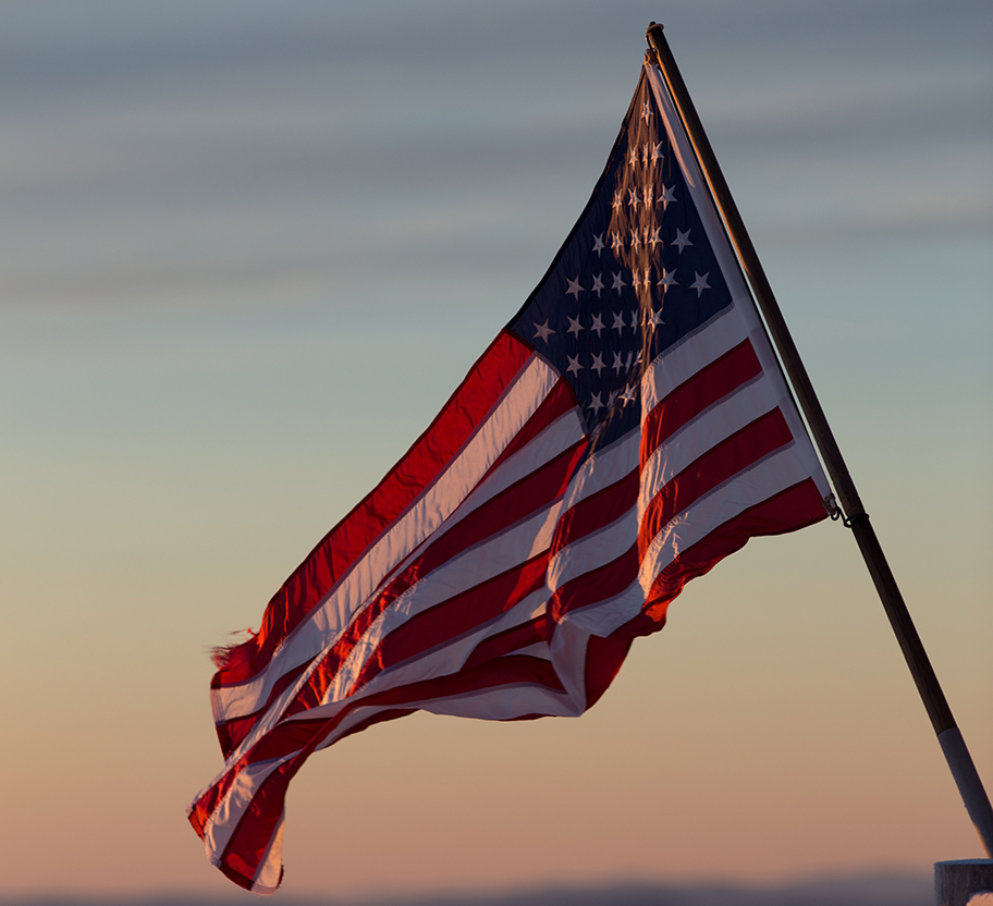 United States flag waving at sunset