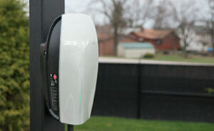 White and black electric hanging Tesla car charging station outside.