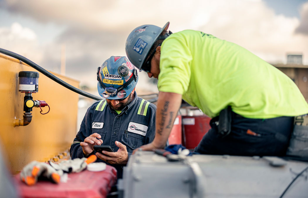 Two Site Services employees calibrating a machine