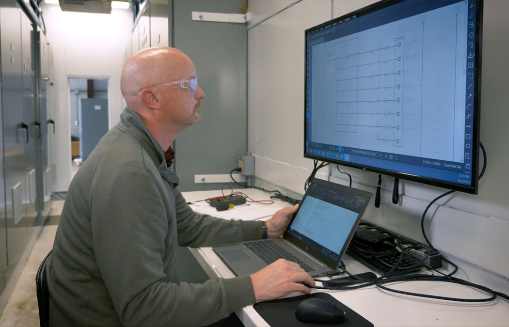 Man working on a computer evaluating Morgan electrical system