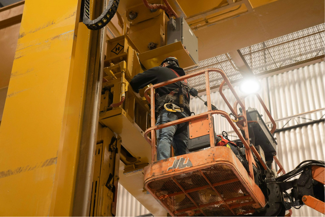 Man working on a Heppenstall crane while standing in a boom lift