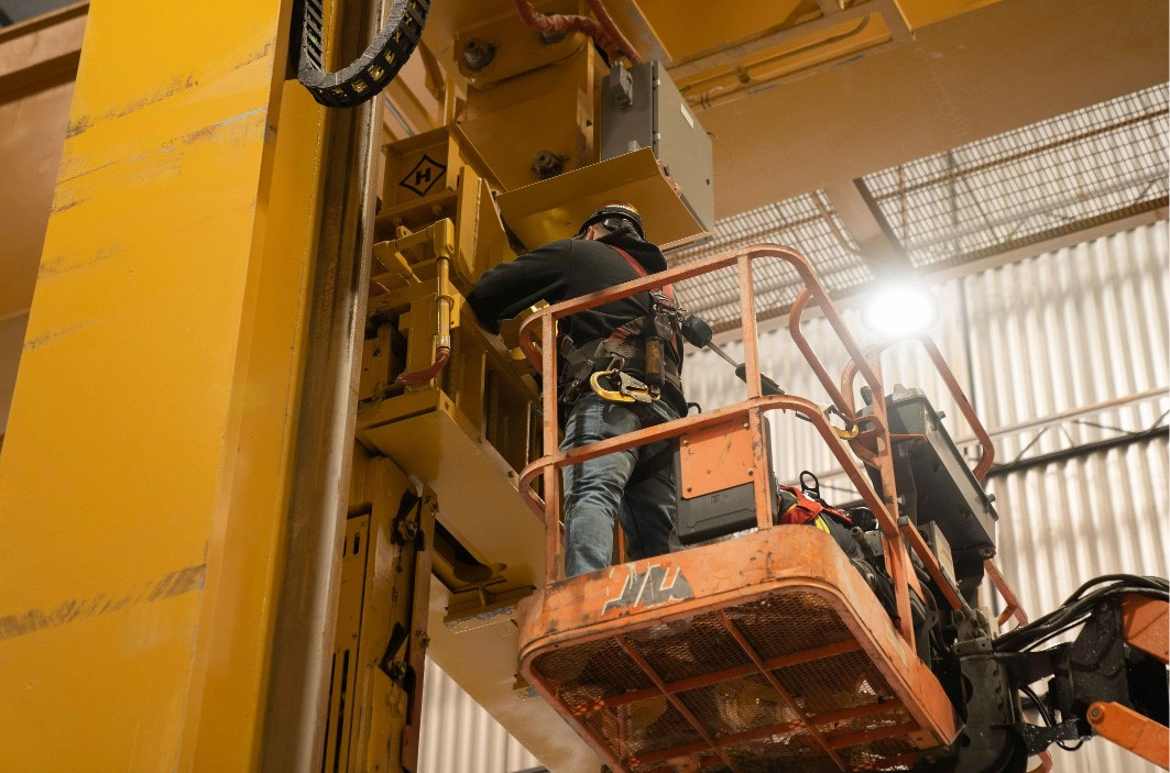 Man repairing a crane while suspended in the air