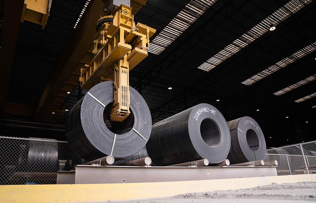 Roll of steel being lifted by a crane.